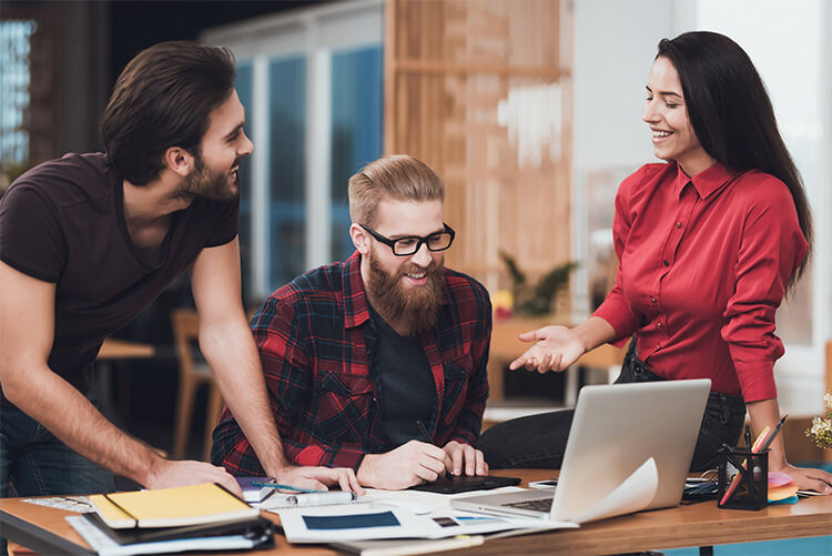 Three people having a discussion while working